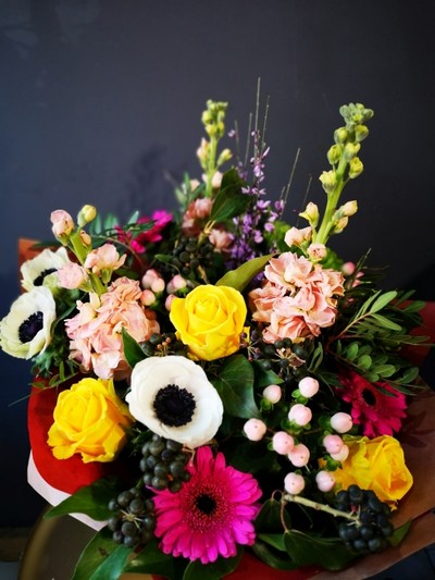 mixed spring flowers bouquet to include Anemones, scented stock, genista, berries, daisy and roses handmade by local florist in Croydon, Surrey, UK