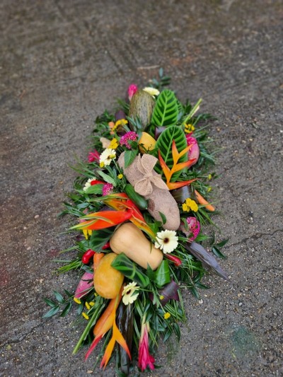 Caribbean funeral Coffin Spray with mixed tropical flowers and veggies done by florist in Croydon for free local delivery 