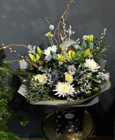 Wonderful bouquet with white lilies, blooms, winter foliages, silver pines, white decorations and twigs. Bouquet is 80cm tall. Made by independent florist in Croydon, Surrey, UK with guaranteed Christmas delivery.