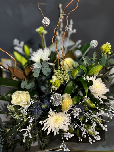 Wonderful bouquet with white lilies, blooms, winter foliages, silver pines, white decorations and twigs. Bouquet is 80cm tall. Made by independent florist in Croydon, Surrey, UK with guaranteed Christmas delivery.