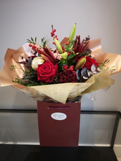 Florist choice of flowers to include ilex, red flowers, nice foliages, pines. Arranged by florist in Croydon.