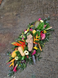 Caribbean funeral Coffin Spray with mixed tropical flowers and veggies done by florist in Croydon for free local delivery 