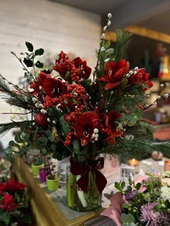 Amazing display of Amaryllis, twigs, Roses, Ilex in tall vase presented with Christmas foliages and scented Eucalyptus.  Definitely a wow factor centerpiece to be placed next to the fireplace or on the sideboard.  Made by independent florist in Croydon, Surrey, UK for guaranteed Christmas delivery 