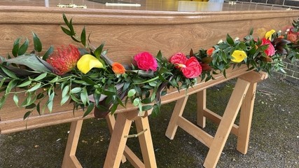 Tripical funeral garland installation by florist from Croydon, Surrey